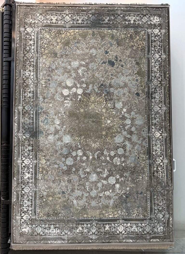 A cream embossed vintage-style Persian machine-made carpet by Kazmi Carpets shown beside wooden furniture tones